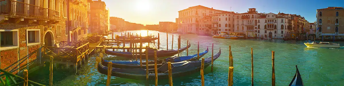 Panoramic photo of gondolas in the sunset Grand Canal in spring Venice.